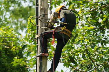 technician climbing electric poles and connecting wires
