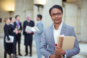 Lawyer standing with documents in courthouse