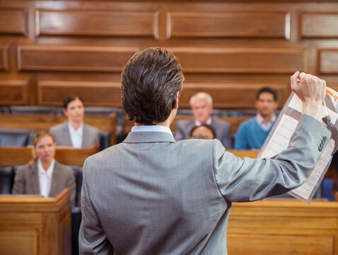 Lawyer showing documents to jury in court 
