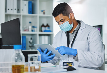 Scientist man, tablet and typing in lab for medical, pharmaceutical or covid research in face mask....