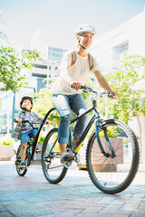 Mother and son riding bicycles on urban path