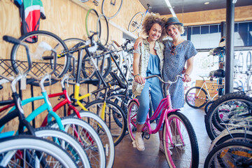 Fototapeta na wymiar Portrait smiling women hugging with bicycle in bicycle shop