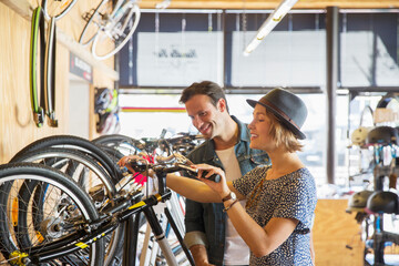 Couple looking at price tags on bicycles in bicycle shop