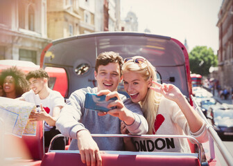 Couple taking selfie on double-decker bus, London, United Kingdom