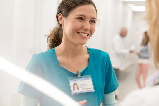 Smiling nurse talking to doctor in hospital corridor