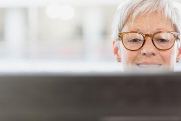 Senior businesswoman with eyeglasses using computer