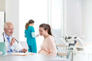 Doctor and pregnant patient discussing prescription in clinic