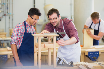 Carpenters measuring wood in workshop