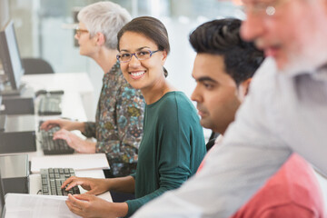 Portrait smiling woman at computer in adult education classroom