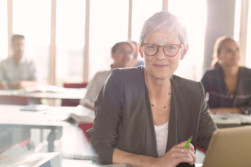 Portrait smiling senior woman at laptop in adult education classroom