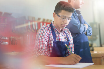 Carpentry student taking notes in workshop