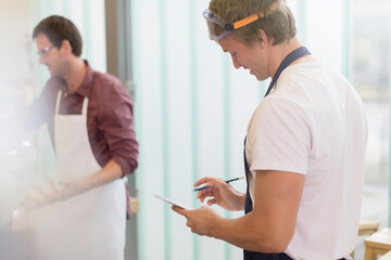 Fototapeta premium Carpenter reviewing notes in workshop