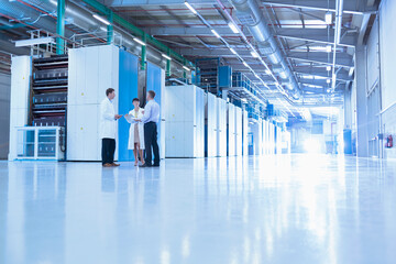 Scientists and businessman talking in factory