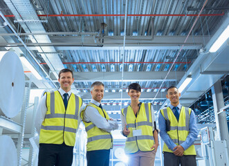 Portrait smiling workers in reflective clothing in factory