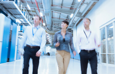 Business people walking in factory corridor