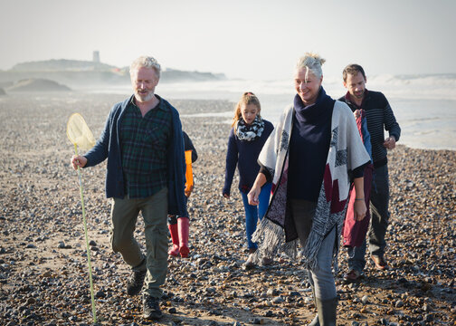 Multi-generation family walking on sunny beach