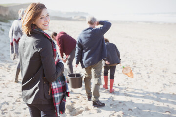Portrait smiling woman walking on sunny beach with family