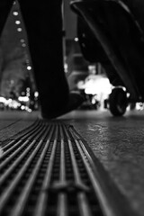 drain in the city with somebody walking over it