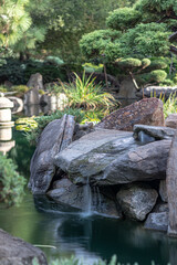 luscious japanese garden with a calm river and large rocks