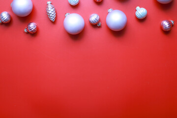 Flat lay Christmas toys on a red background. Pink toys for the Christmas tree