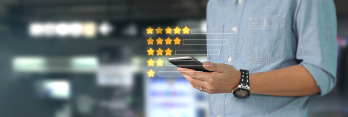 Man holding smartphone device and touching screen with five star rating feedback