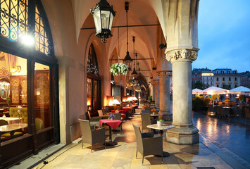 Cafe in Sukiennice - old malls on the Main Market Square (Rynek Glowny) in evening time in Krakow, Poland