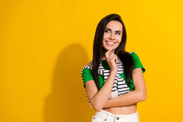 Photo of tricky cunning girl dressed green t-shirt arm chin looking empty space isolated yellow...