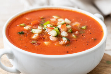 Traditional Spanish gazpacho soup in bowl on wooden table. Close up