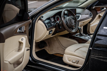 Luxury modern car interior. Steering wheel, shift lever, speedometer, display, gearbox handle, and...