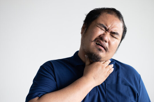 Middle Aged Asian Man Having Sore Throat From Cold, Flu, Inflammation Or Infection