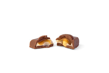 Broken pieces of milk chocolate with toffee and nut on a white background.