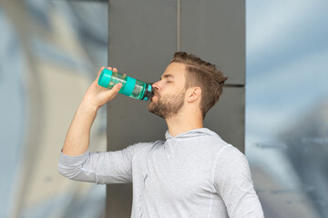 Fototapeta na wymiar thirsty sportsman drinking water outdoor. photo of thirsty sportsman with water after training