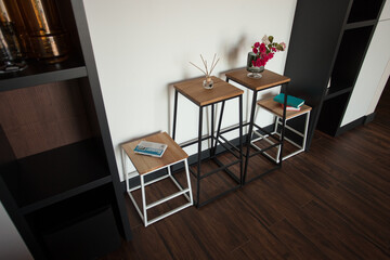 Shabby wooden table with chairs and vase located near comfortable couch against light walls with decorations in modern apartment. High quality photo