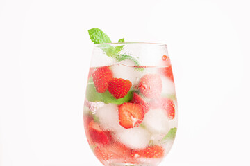 Summer strawberry cocktail on white background. Cold refreshing strawberry lemonade or mojito cocktail with ice cubes and fresh mint leaves.