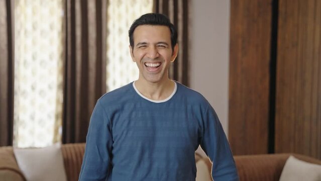 Middle aged Indian man laughing on someone