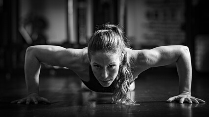 Fototapeta na wymiar Woman Doing Push-ups in the gym. Strength Training.
