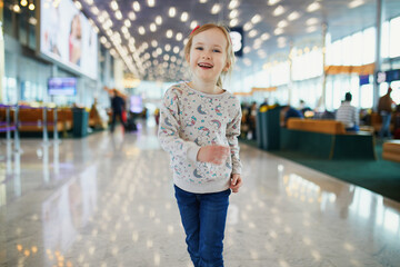 Adorable preschooler girl having fun in international airport