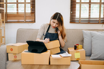 .Asian woman SME working with a box at home the workplace.start-up small business owner, small...