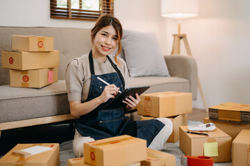 Fototapeta na wymiar Small business entrepreneur SME freelance woman working at home office, BOX,tablet and laptop online, marketing, packaging, delivery, e-commerce concept