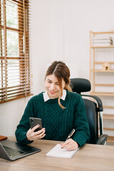 businesswoman hand working with new modern computer and writing on the notepad strategy diagram as concept morning light.