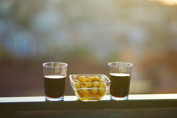 Two glasses of red wine and green olives with view to the roofs of Uskudar district on Asian side of Istanbul, Turkey