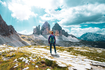 Naklejka premium Young athletic woman enjoys view on Monte Paterno and Tre Cime at noon. Tre Cime, Dolomites, South Tirol, Italy, Europe.