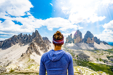 Young athletic woman enjoys view on Monte Paterno and  Tre Cime at noon. Tre Cime, Dolomites, South Tirol, Italy, Europe.