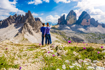 Young athletic couple enjoys summit of Sasso di Sesto in the afternoon. Tre Cime, Dolomites, South Tirol, Italy, Europe. - obrazy, fototapety, plakaty