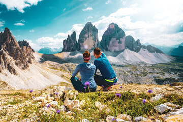 Young athletic couple enjoys scenic view on Monte Paterno and Tre Cime in the afternoon. Tre Cime,...