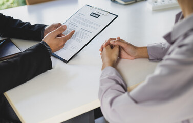 Woman submits an application to the personnel committee. The manager reads the resume and discusses...