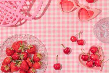 Summer creative layout with strawberries, cherries, glass with ice cubes, heart sunglasses and...