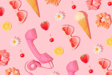 Summer creative pattern made with heart sunglasses, ice cream, retro phone handset, scrunchies, strawberry, cherry, lemon, white flower on pastel pink background. 80s or 90s retro fashion girl idea. 