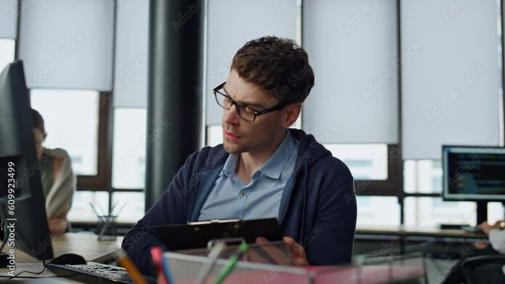 Aufkleber it manager analysing online report. thoughtful software engineer making notes