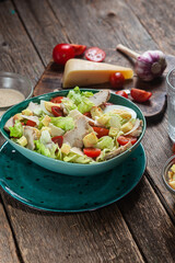 Appetizing Caesar salad in a plate on a wooden table